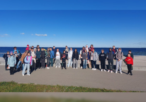 Uczniowie na grupowym zdjęciu na plaży.