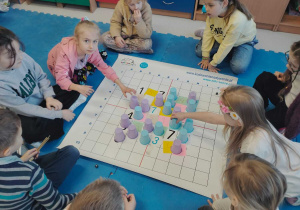 Uczniowie kodują wyniki na macie do kodowania.