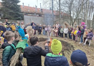 Uczniowie z marzannami przy ognisku.