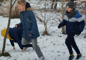 Chłopcy podczas zimowej zabawy w ganianego.