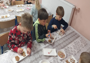Chłopcy z klasy 1b podczas dekorowania pierników.