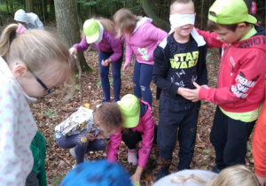 Uczniowie podczas zabawy w lesie.