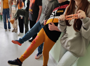 Uczniowie klasy pokazują ubrania w kolorze pomarańczowym.