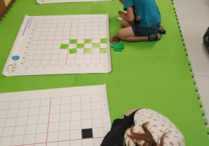 Uczniowie w trakcie odczytywania kodów i tworzenia obrazków.