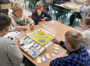 Uczniowie grający w planszówkę.