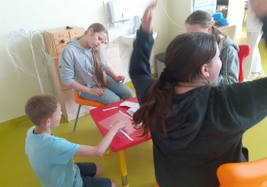 Uczniowie wspólnie spędzają czas w bibliotece.
