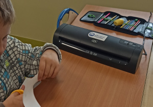 Uczeń w trakcie przygotowywania kart.