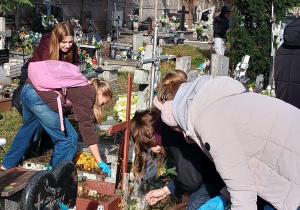 Uczniowie klasy 6 podczas sprzątania grobów.