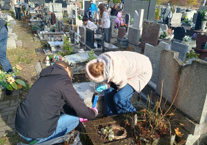 Uczniowie klasy 7 podczas sprzątania grobów.