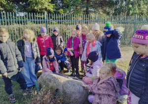 Uczniowie przy kamieniu pamiątkowym.