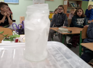 Zamarznięta woda wystająca ponad brzeg słoika.