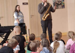 Muzyk prezentuje flet macedoński.