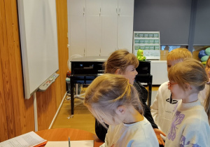 Uczniowie wpisują się do księgi.