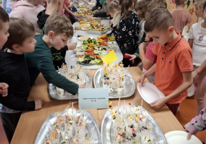 Uczniowie częstują się zdrowymi przekąskami.