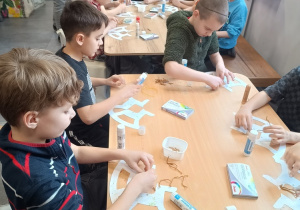 Uczniowie w trakcie wykonywania koników na biegunach.