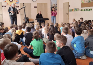 Uczniowie klaszczą w rytm muzyki.