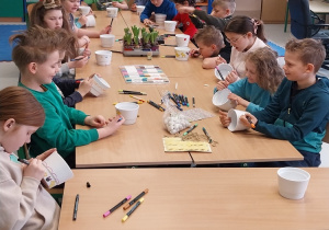 Uczniowie klasy 3b w trakcie dekorowania doniczek na hiacynty.