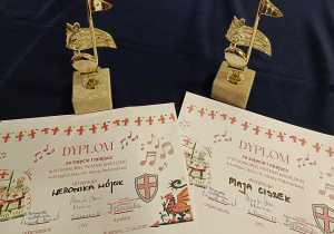 Statuetki z dyplomami.
