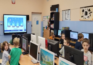 Uczniowie klas 1-3 podczas rozwiązywania zagadek w świątecznym escape roomie w sali komputerowej.